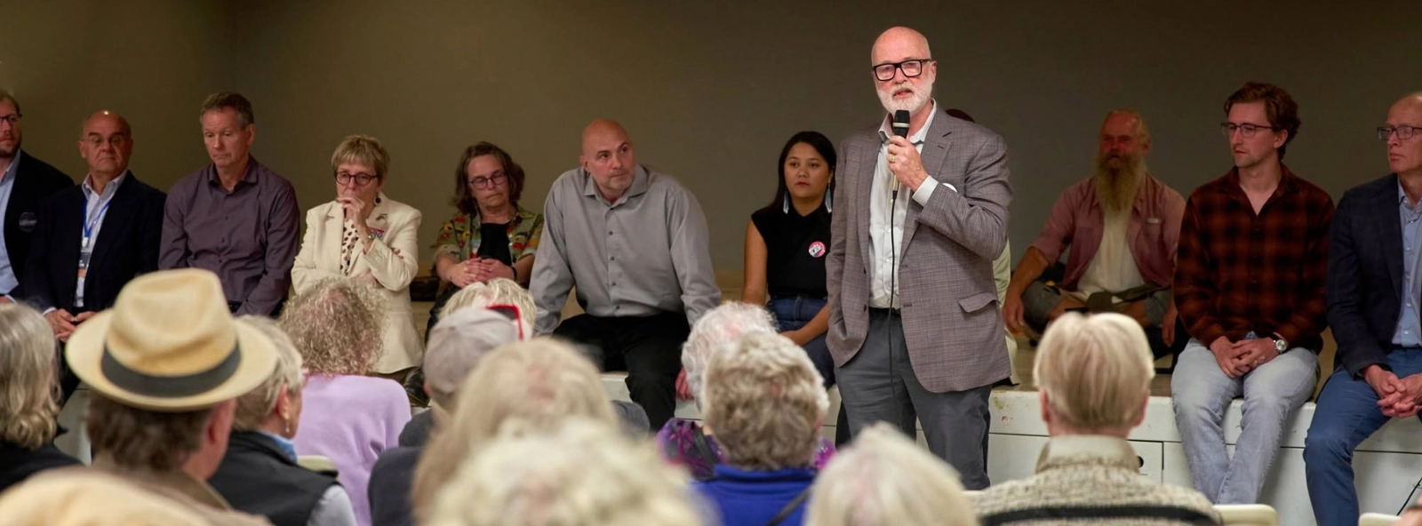 Bruce speaking at an event, in dialogue with a crowd.